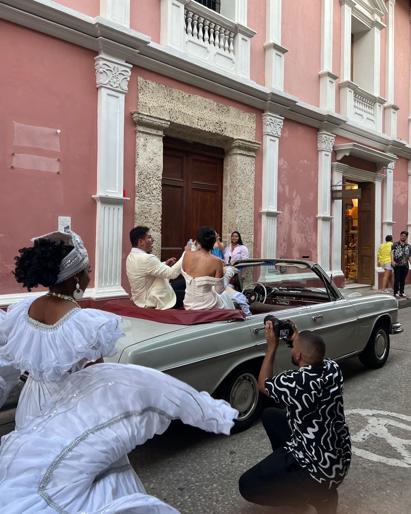 BTS wedding Photographer candid moment catching a wedding couple in a vintage car