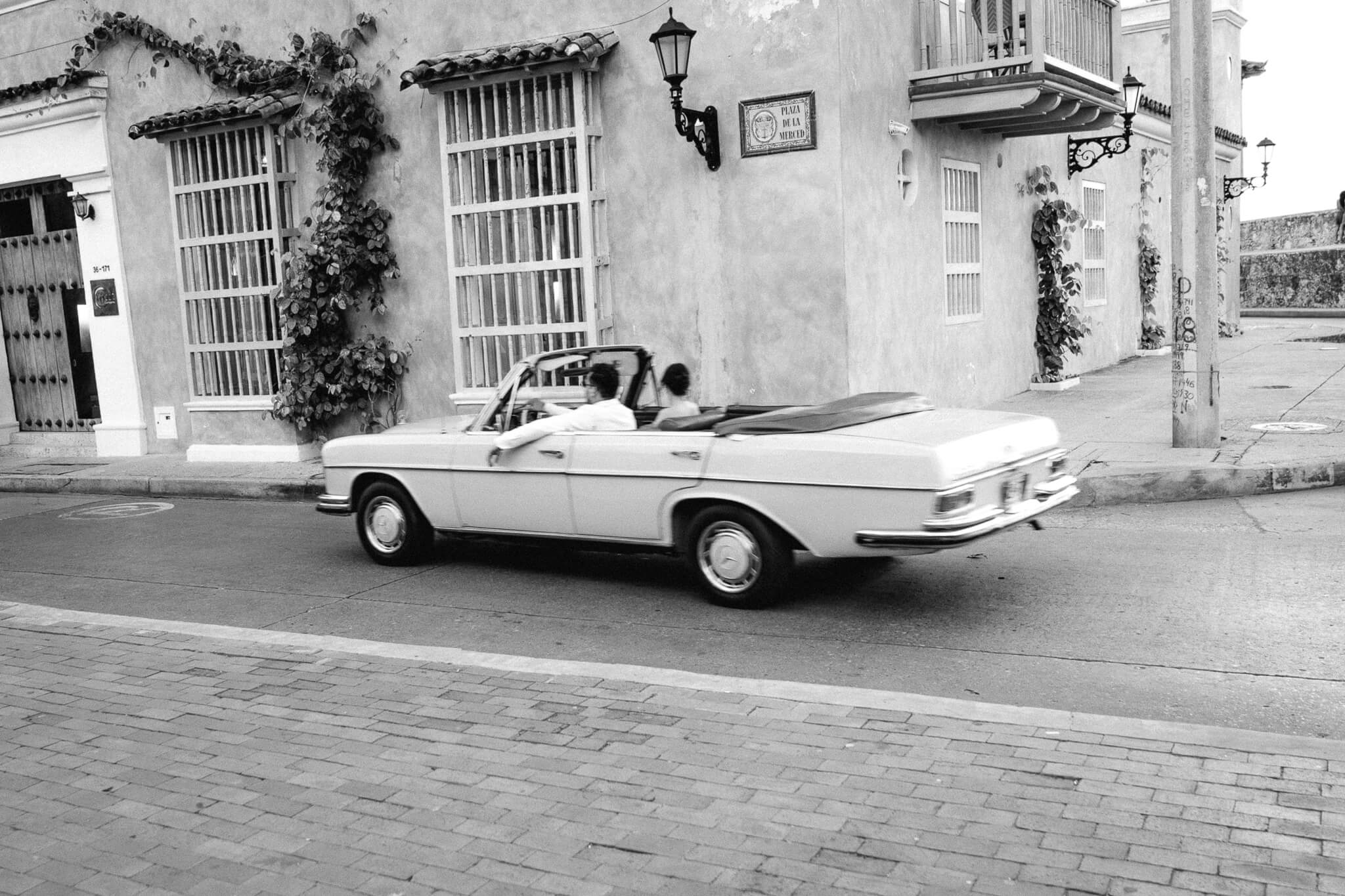  Cartagena wedding couple in a  vintage car traveling through the streets
