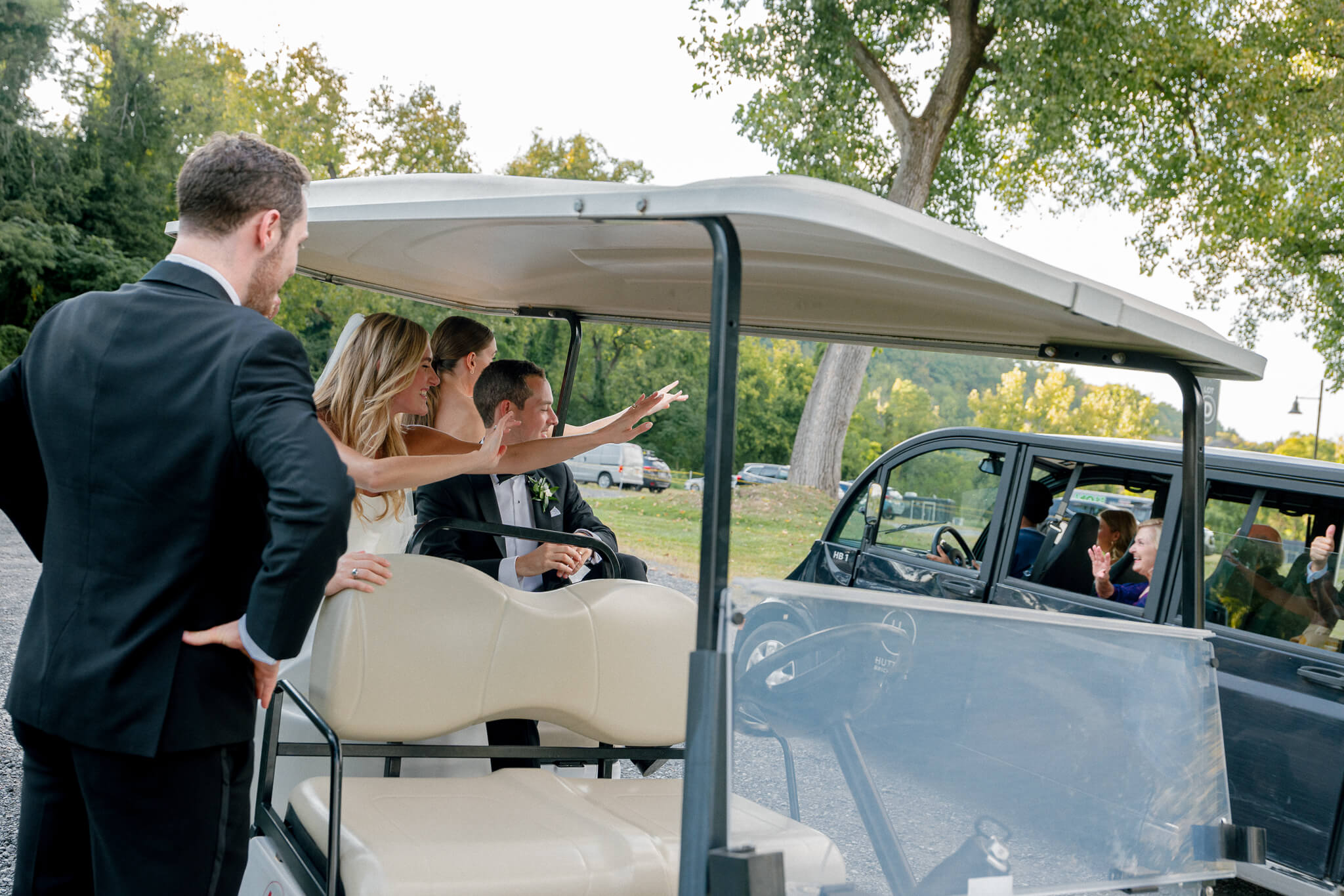 Hudson Valley wedding in Hutton Brickyards moment after ceremony where guest and bride and groom are interacting within a golf cart