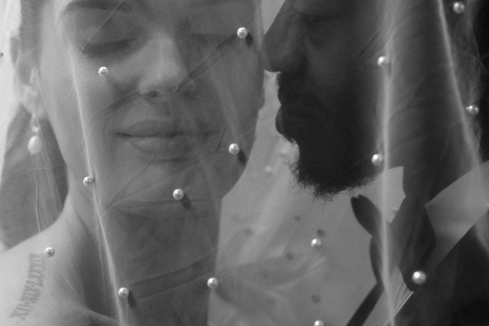 editorial couple portrait under a veil with both loving and experiencing each others caringly