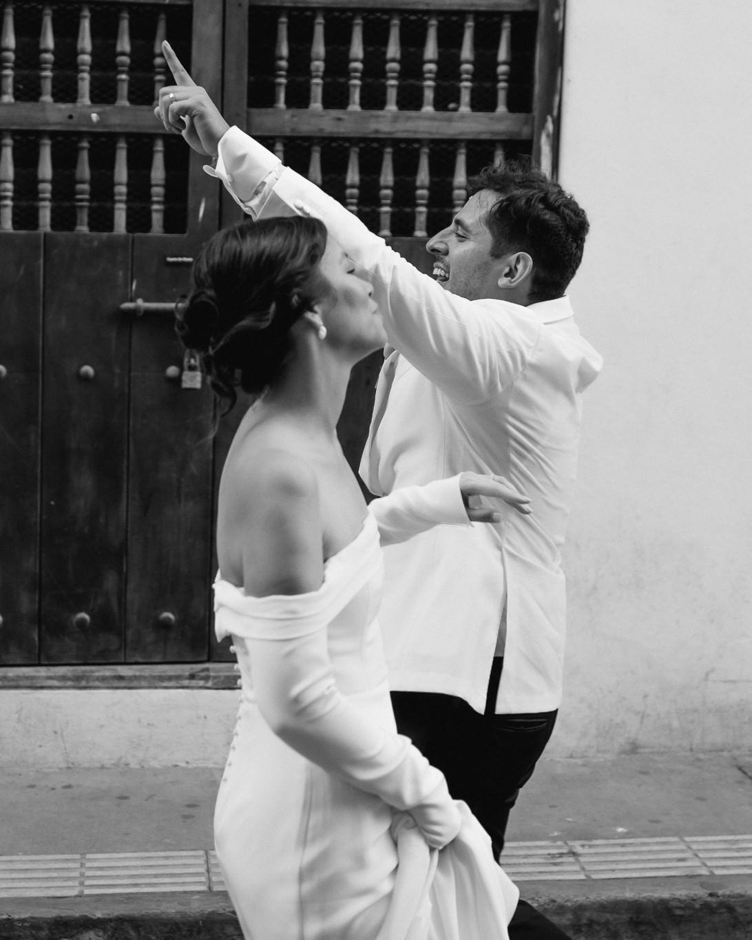 cartagena wedding couple happy and pointing at something in the crowd in the streets celebrating