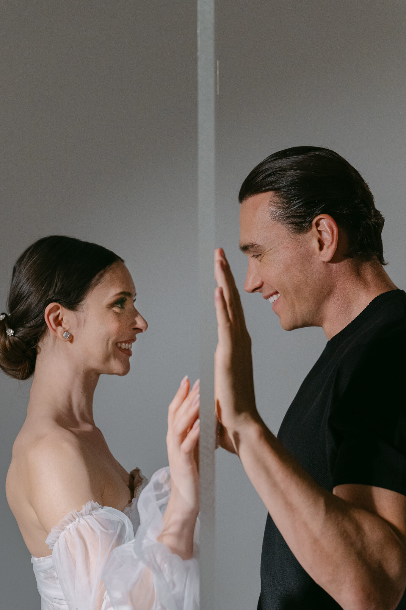 editorial couple portrait hand to hand on a mirrow laughing and smiling