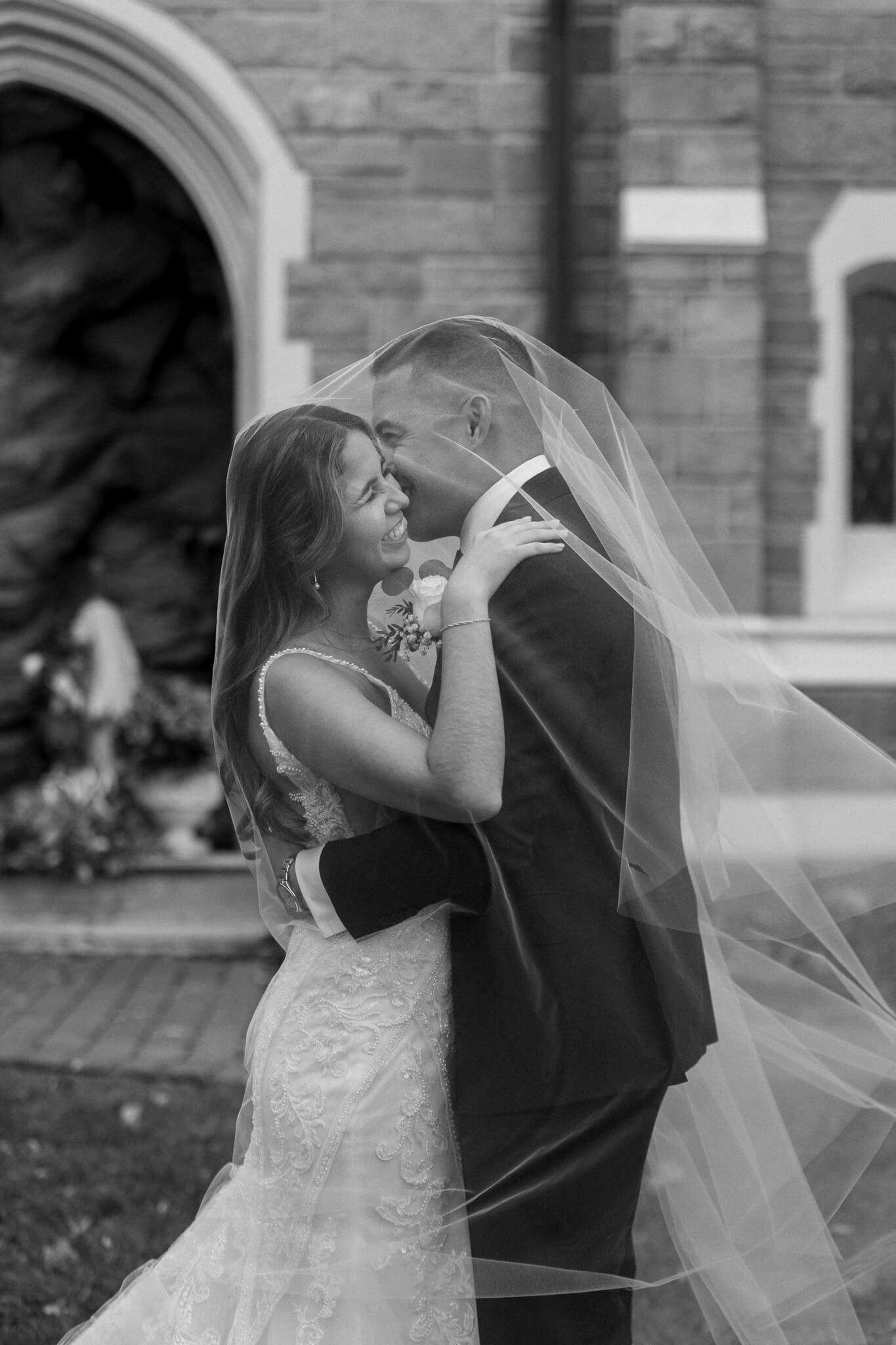 new jersey couple under their veil laughing and celebrating one another for their portraits